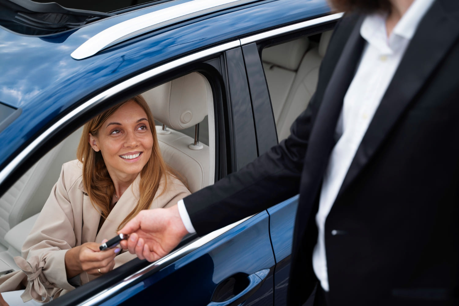 un homme donne des clés de voiture à une femme assise dans un véhicule. Il s'agit d'un symbole d autopartage