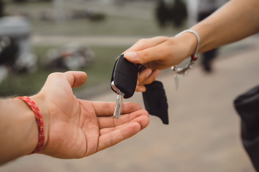 autopartage : une femme donne les clés de voiture à un homme