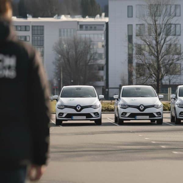 véhicules d'entreprises stationné avec agent se dirigeant vers l'un d'eux.